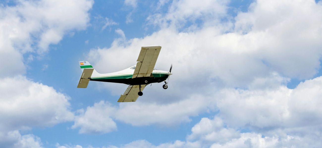 Single engine ultralight plane flying in the cloudy blue sky